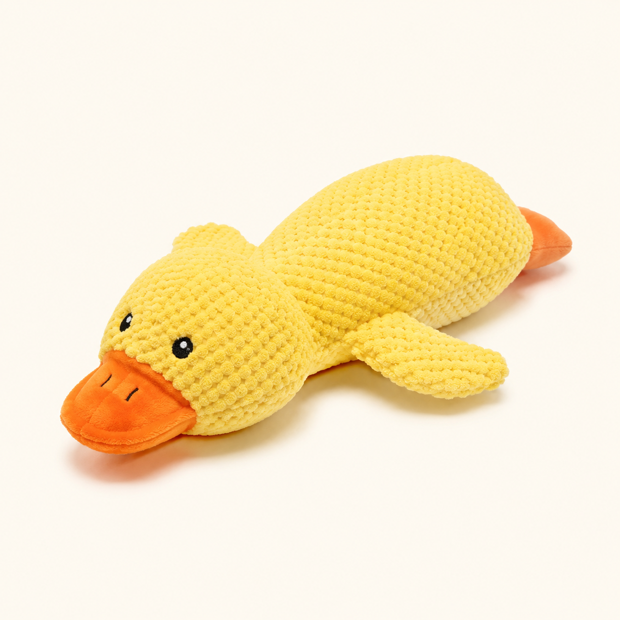Medium yellow plush squeaky duck dog toy on cream background