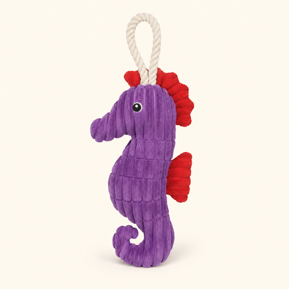 Purple crinkle plush seahorse squeaky dog toy with rope loop on cream background